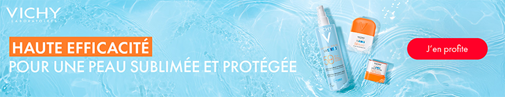 Fond bleu clair avec un effet d’eau. Le message principal affiche « HAUTE EFFICACITÉ POUR UNE PEAU SUBLIMÉE ET PROTÉGÉE ». Un bouton rouge affiche « J’en profite ». À droite sont présentés trois produits solaires Vichy Capital Soleil flottant sur le fond aquatique : un spray UV-Age Daily SPF 50+, un stick SPF 50+ et un petit flacon de protection solaire